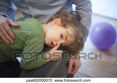 Stock Image - Toddler boy resting head on father's lap. Fotosearch