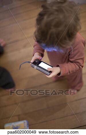 Stock Photo - Toddler looking at digital camera. Fotosearch
