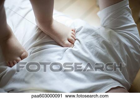 Child's feet on father's chest View Large Photo Image Stock Image - Child's feet on father's chest. Fotosearch