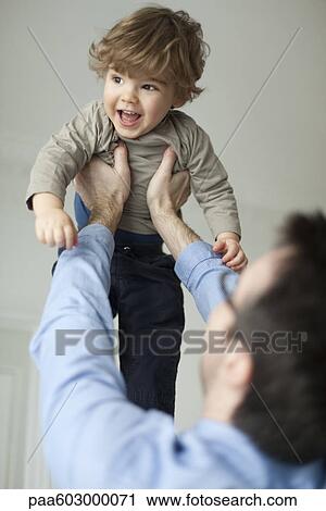Father holding up toddler son View Large Photo Image Stock Image - Father holding up toddler son. Fotosearch