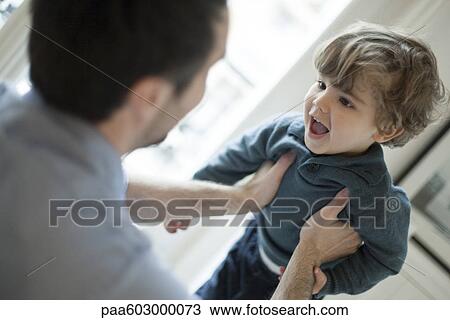 Father holding up toddler son View Large Photo Image Stock Image - Father holding up toddler son. Fotosearch