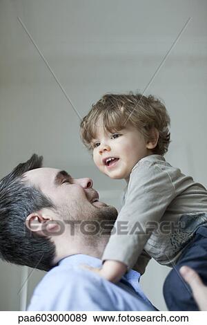 Father holding up young son, portrait View Large Photo Image Stock Photo - Father holding up young son, portrait. Fotosearch