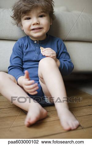 Stock Image - Little boy eating cookie, portrait. Fotosearch