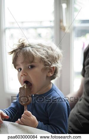Toddler boy eating ice cream bar View Large Photo Image Picture - Toddler boy eating ice cream bar. Fotosearch