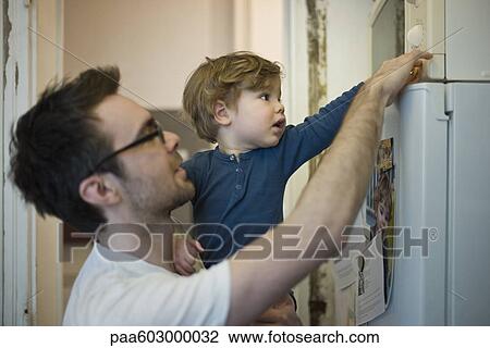 Toddler boy helping father using microwave View Large Photo Image Stock Image - Toddler boy helping father using microwave. Fotosearch