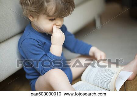 Toddler boy looking at book View Large Photo Image Stock Image - Toddler boy looking at book. Fotosearch