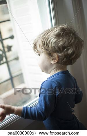 Toddler boy looking out window View Large Photo Image Stock Photo - Toddler boy looking out window. Fotosearch