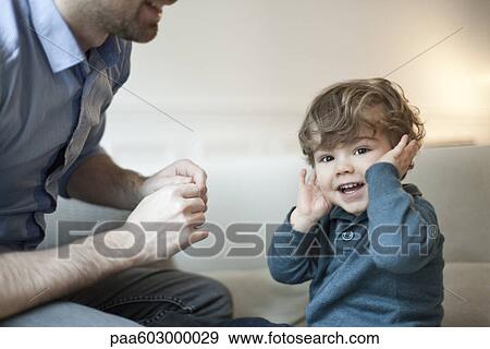 Stock Photo - Toddler boy playing with father, portrait. Fotosearch