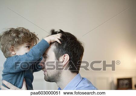 Toddler boy playing with father's hair View Large Photo Image Stock Image - Toddler boy playing with father's hair. Fotosearch
