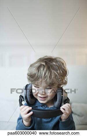 Toddler boy playing with headphones, portrait View Large Photo Image Stock Image - Toddler boy playing with headphones, portrait. Fotosearch