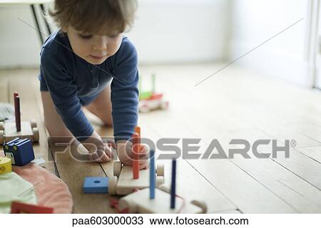 Toddler boy playing with toy train View Large Photo Image Stock Image - Toddler boy playing with toy train. Fotosearch
