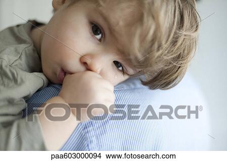 Toddler boy resting head on parent's shoulder, tears on face View Large Photo Image Picture - Toddler boy resting head on parent's shoulder, tears on face. Fotosearch