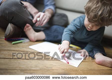 Toddler boy sitting on floor with parent, drawing on paper View Large Photo Image Stock Photograph - Toddler boy sitting on floor with parent, drawing on paper. Fotosearch