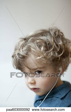 Toddler boy wearing earphones, portrait View Large Photo Image Stock Image - Toddler boy wearing earphones, portrait. Fotosearch