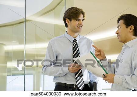 Businessmen discussing document View Large Photo Image Stock Image - Businessmen discussing document. Fotosearch