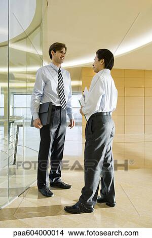Businessmen talking in corridor View Large Photo Image Picture - Businessmen talking in corridor. Fotosearch
