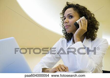 Picture - Businesswoman using cell phone. Fotosearch
