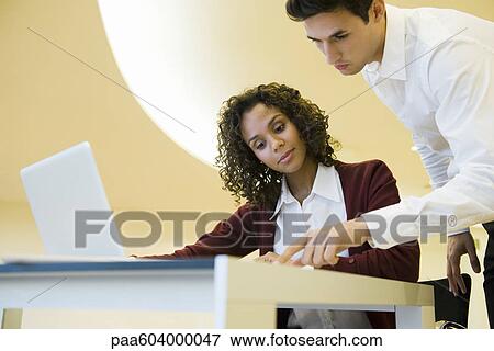 Stock Photo - Colleagues looking at documents together. Fotosearch