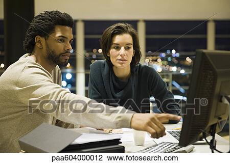 Colleagues working on project together in office at night View Large Photo Image Stock Image - Colleagues working on project together in office at night. Fotosearch