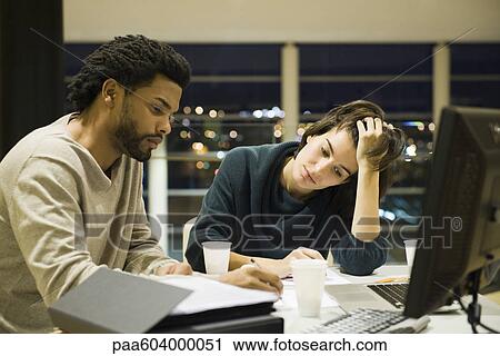 Colleagues working on project together in office at night View Large Photo Image Stock Image - Colleagues working on project together in office at night. Fotosearch