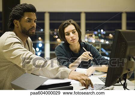 Colleagues working on project together in office at night View Large Photo Image Stock Photo - Colleagues working on project together in office at night. Fotosearch