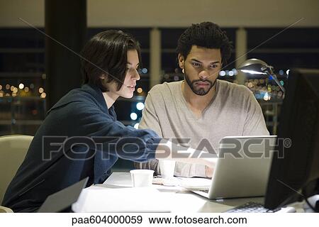 Colleagues working on project together in office at night View Large Photo Image Stock Photo - Colleagues working on project together in office at night. Fotosearch