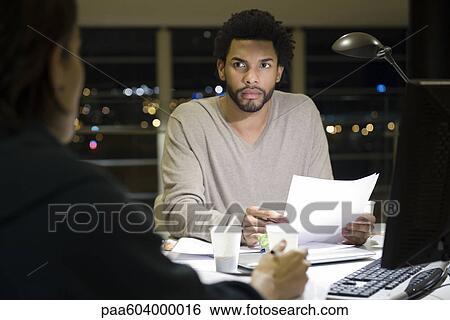 Colleagues working on project together in office at night View Large Photo Image Stock Photograph - Colleagues working on project together in office at night. Fotosearch