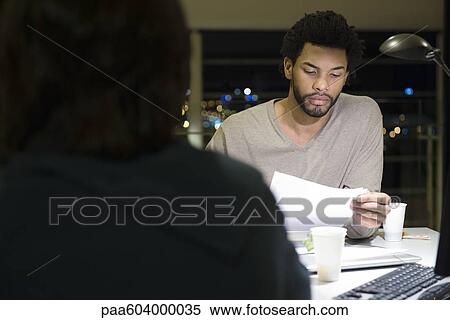 Colleagues working on project together in office at night View Large Photo Image Stock Photography - Colleagues working on project together in office at night. Fotosearch