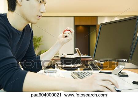 Office worker using computer, squeezing stress ball with one hand View Large Photo Image Stock Image - Office worker using computer, squeezing stress ball with one hand. Fotosearch