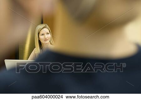 Woman looking away in thought, man in foreground View Large Photo Image Picture - Woman looking away in thought, man in foreground. Fotosearch