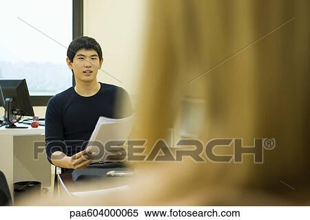Young office worker sitting in meeting View Large Photo Image Stock Photography - Young office worker sitting in meeting. Fotosearch