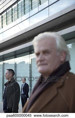 Businessmen standing in front of building View Large Photo Image Stock Photography - Businessmen standing in front of building. Fotosearch