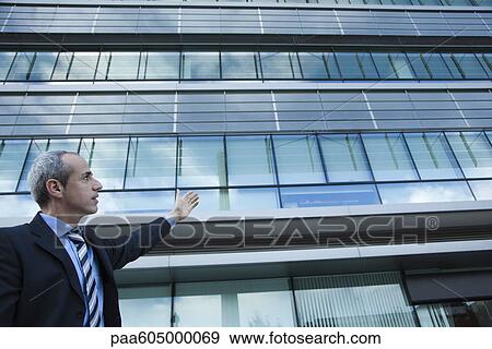 Stock Photo - Executive gesturing at office building. Fotosearch