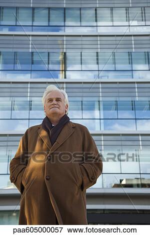 Executive standing in front of office building, portrait View Large Photo Image Stock Photo - Executive standing in front of office building, portrait. Fotosearch