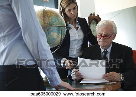 Executives discussing document View Large Photo Image Stock Photo - Executives discussing document. Fotosearch
