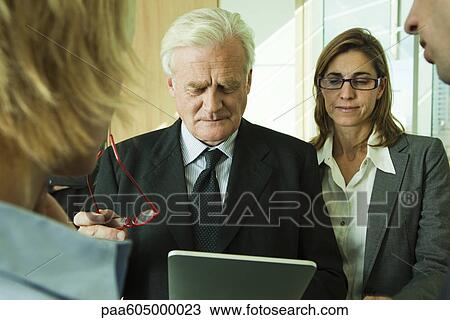 Executives examining information on digital tablet View Large Photo Image Stock Image - Executives examining information on digital tablet. Fotosearch
