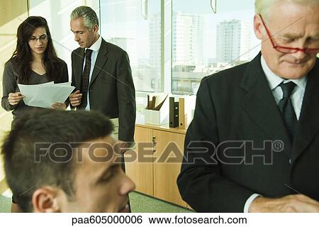 Executives working with young associates in office View Large Photo Image Stock Photograph - Executives working with young associates in office. Fotosearch