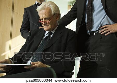 Mature executive using digital tablet View Large Photo Image Picture - Mature executive using digital tablet. Fotosearch