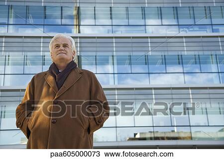 Mature man standing in front of building, looking away, portrait View Large Photo Image Stock Image - Mature man standing in front of building, looking away, portrait. Fotosearch