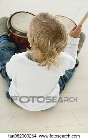 Picture - Baby boy playing drums, rear view. Fotosearch