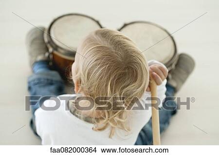 Picture - Baby boy playing drums, rear view. Fotosearch