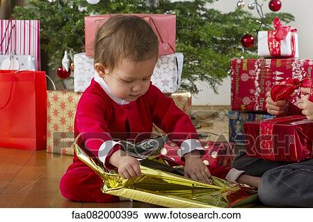 Baby girl unwrapping Christmas present View Large Photo Image Stock Photography - Baby girl unwrapping Christmas present. Fotosearch