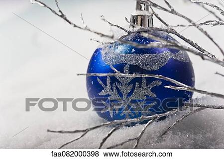 Stock Photo - Blue bauble in snow. Fotosearch
