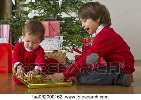 Boy helping his baby sister open Christmas presents View Large Photo Image Stock Image - Boy helping his baby sister open Christmas presents. Fotosearch