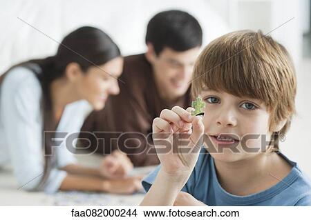 Boy holding piece of jigsaw puzzle View Large Photo Image Picture - Boy holding piece of jigsaw puzzle. Fotosearch