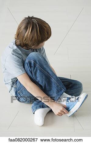 Boy putting shoes on View Large Photo Image Stock Photo - Boy putting shoes on. Fotosearch