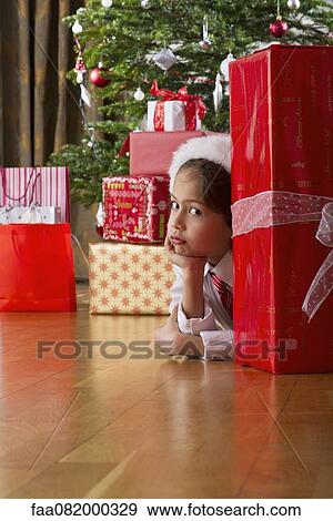 Boy waiting impatiently behind large Christmas present View Large Photo Image Stock Photo - Boy waiting impatiently behind large Christmas present. Fotosearch