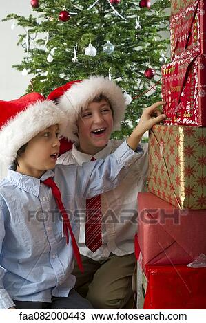 Boys looking excitedly at stack of Christmas presents View Large Photo Image Stock Image - Boys looking excitedly at stack of Christmas presents. Fotosearch