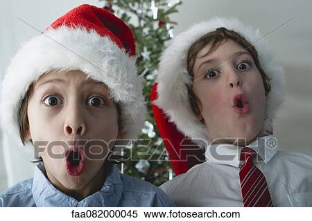Boys wearing Santa hats, making surprised faces View Large Photo Image Stock Photography - Boys wearing Santa hats, making surprised faces. Fotosearch