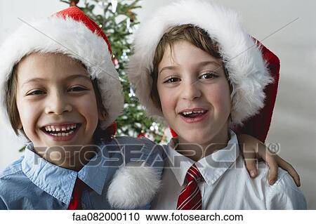 Boys wearing Santa hats, portrait View Large Photo Image Stock Image - Boys wearing Santa hats, portrait. Fotosearch